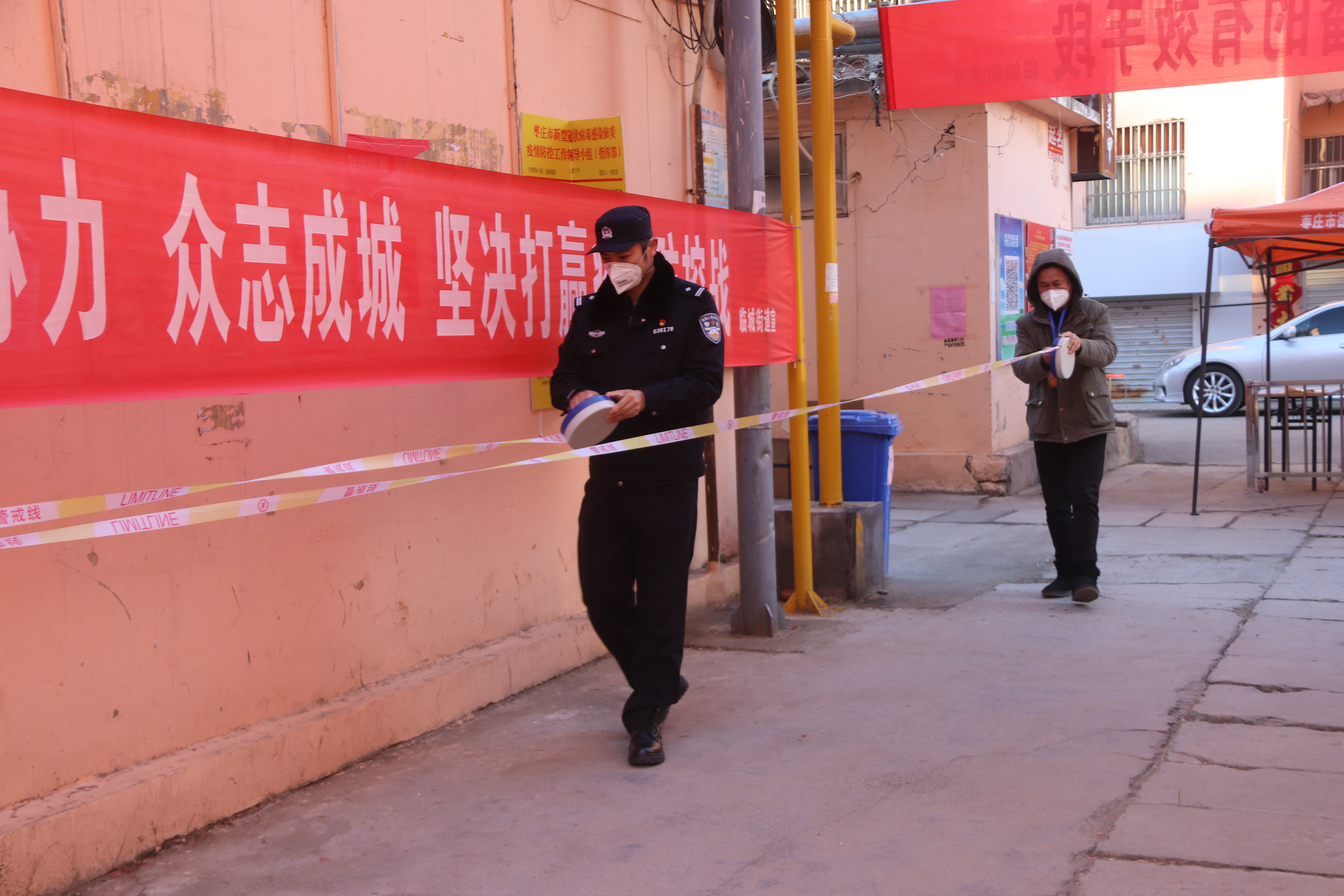 社区工作人员同民警一起撤除隔离警戒线.JPG
